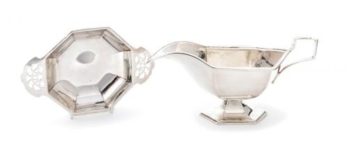 An Art Deco silver plain oval sauce boat with geometric facet sides with similar handle and raised foot, the border with sunbeam decoration, hallmarked by C W Fletcher & Son Ltd, Sheffield, 1933 together with an octagonal plain Quaich style dish with openwork handles, by Viner & Co., Sheffield, 1938 (2) 9.47 ozt  (294.3 grams)