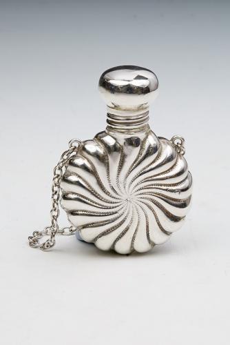 A Victorian small silver circular perfume bottle, radial wyvern fluted, on suspension ring, London 1890