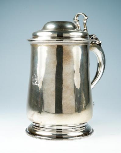 A George II plain silver tankard, the domed cover with cast openwork thumbpiece and S-scroll handle, on spreading circular foot, the body engraved with a crest, London, 1733, maker's mark probably that of Charles Hatfield (see Grimwade London Goldsmiths ref no: 322), 30.35 ozt (944.1 grams)