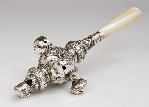 A Victorian silver babies rattle with whistle, with five bells suspended, ornate body and mother-of-pearl teether, Birmingham 1890