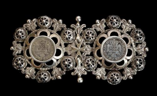 An 18th/19th century Maltese silver buckle, the circular pierced and scroll work buckles joined by a Maltese Cross, inset with two 1776 Maltese Tari (ruler Emmanuel de Rohan, unknown mintage, reverse with Maltese Cross in circle, date in angles, obverse with crowned arms on eagle), approx 12cm long, total gross weight approx 66.9gms/2.15ozt