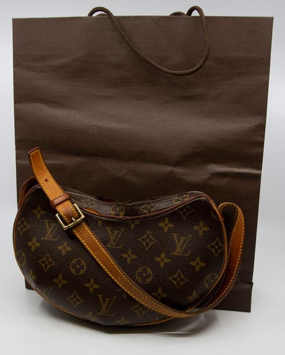 A Louis Vuitton Croissant Bag, monogrammed canvas, 10.5 length approx,  shoulder strap, suede lined. Condition; some damage to zip, wear and tear  to corners, along with the dust bad and original outer
