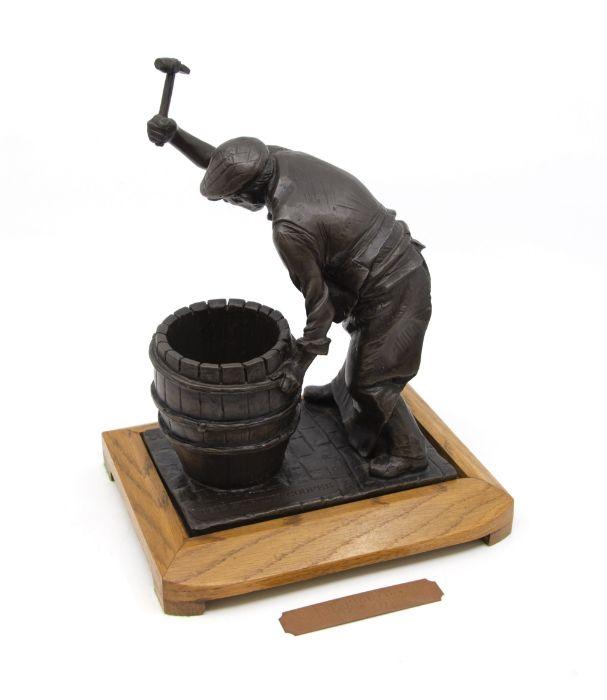 Bronzed figure of the Burton Cooper on wooden stand