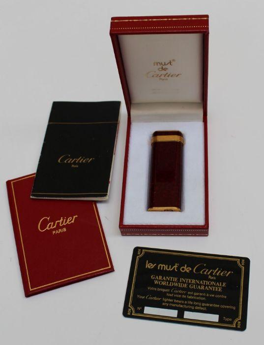 A Must de Cartier red mottled enamel and gold plated cigarette lighter ...