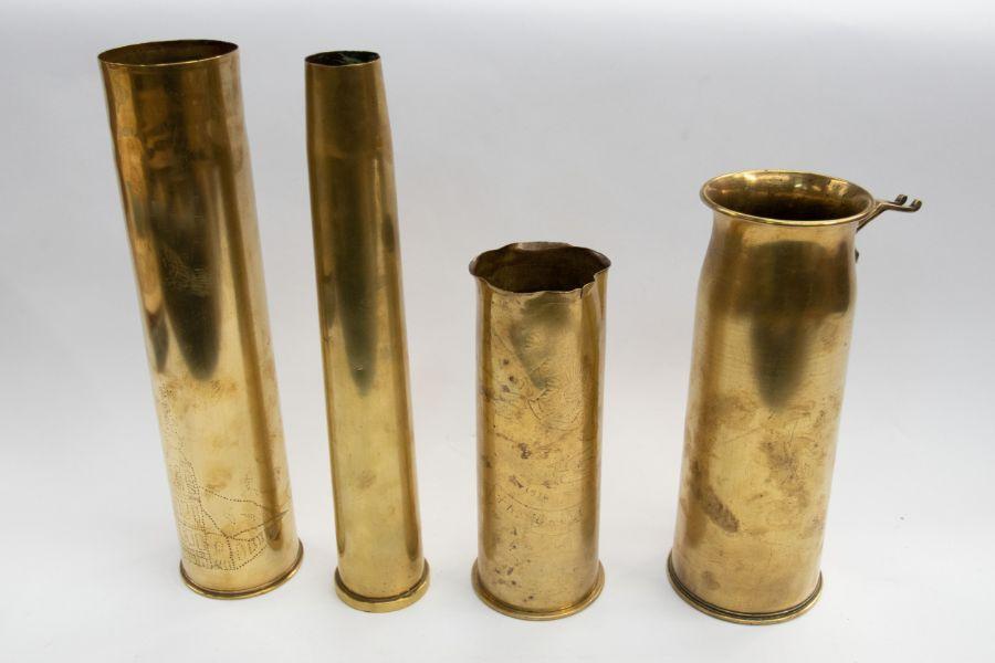 Four brass artillery shells of various dates, including a German 75mm shell,  dated 1917, faint engraving featuring the Cheshire regiment badge, 23cms  high approx, a German 75mm shell case, with dot pricked