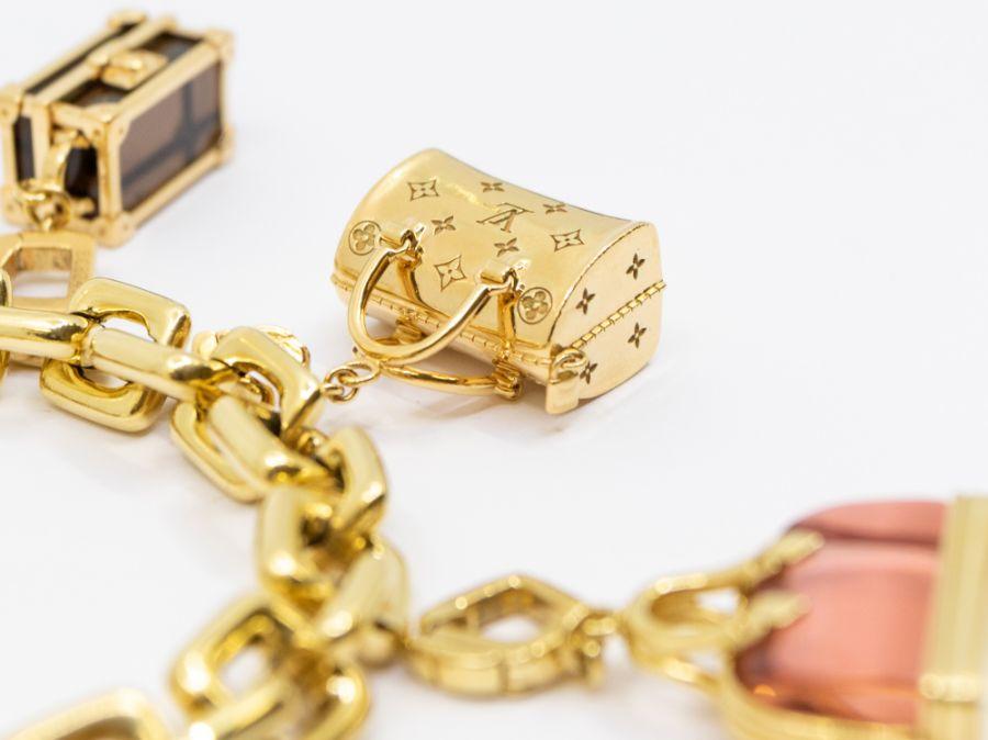 LOT:493  LOUIS VUITTON - an 18ct gold charm bracelet with padlock