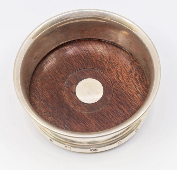 A Modern silver plain wine coaster turned wooden base hallmarked