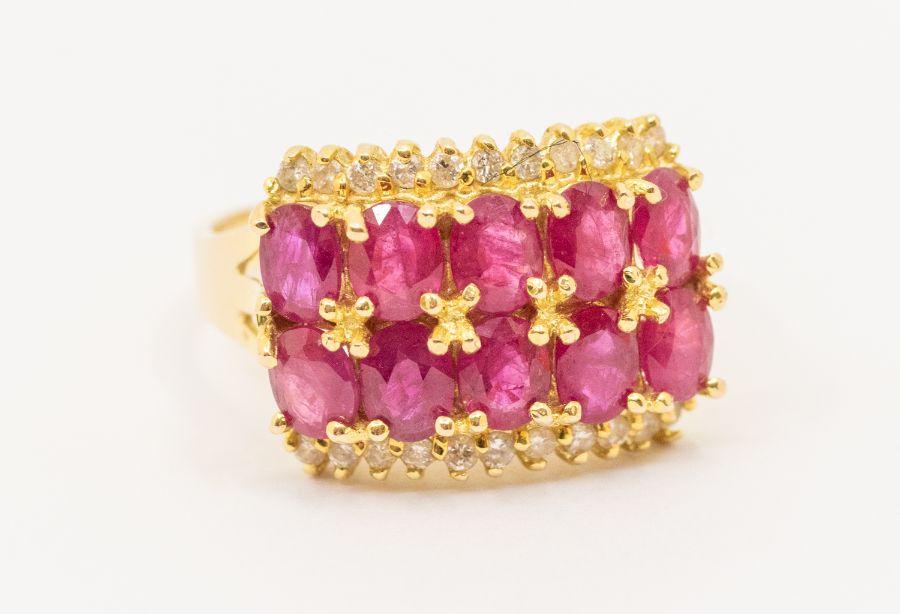 A ruby and diamond 14ct gold ring, comprising a double row of oval ...