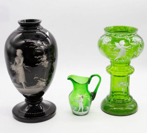 Three items of 19th/20th century enamelled glass, all in the style of Mary Gregory, to include; a tall green vase, small green jug and a tall black and white enamel vase. 
 Further Details: Some chips to rim of green vase, surface wear and scratching to all.