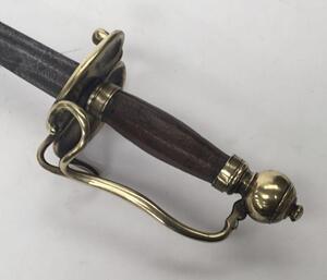 An 18th century English or possibly Dutch small sword.
 Brass kidney shaped double lobed cross guard, with brass knuckle bow and quillon.
 Brass pommel into which the knuckle bow is fitted.
 Polished wooden handle of octagonal cross section.
 Single edged - 3