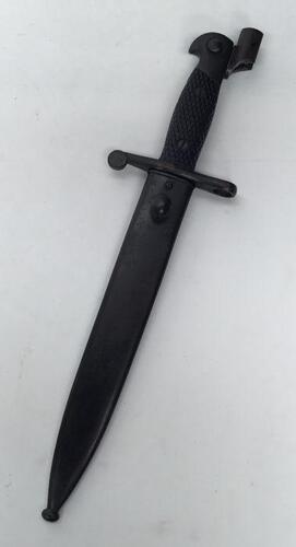 A Spanish M1941 Mauser Bolo bayonet, complete with adapter for the M1943 Mauser.
 Standard chequered grips secured by 2 screws.
 Darkened steel pommel and cross guard.
 Single edged blade with fuller to both sides.
 Marked ‘Toledo FN’ to the ricasso.
 Ser