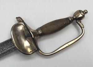 A 1796 pattern infantry officer's sword.
 Brass fold down guard, knuckle guard and pommel.
 Wooden handle that would of formally had a wire binding around it.
 Steel single edged blade, with fuller to both sides and flat spine.
 No visible makers marks or - 5