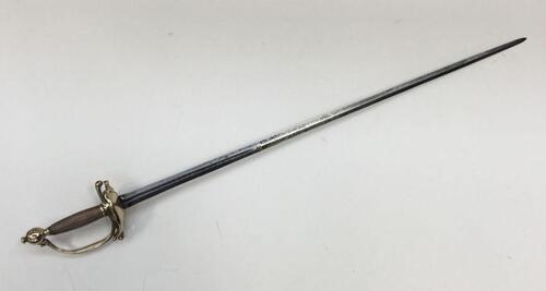 An 18th century continental rapier sword, with brass clamshell guard, knuckle bow and pommel.
 Copper twisted wire binding to the handle.
 Narrow double edged blade, with short but deep fuller to both sides.
 Marked identically to both sides of the blade,