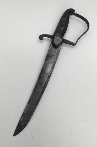 An 1796 pattern Light Cavalry Sabre, drastically shortened to a fighting knife.
 Usual steel cross guard, with shield shaped langets, backpiece, and knuckle bow.
 Ridged handle (now missing its wire binding).
 Single edged steel blade with shallow fuller 