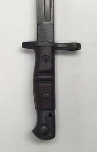 An American P1914 bayonet, with makers mark for Remington and 1917 date at the ricasso.
 Wooden slab grips with usual double grooves to each side.
 Blued pommel, cross guard and ricasso area.
 Single edged blade with fuller to both sides.
 Black leather s - 2