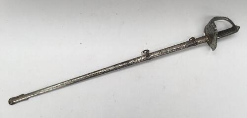 A WW1 era 1897 pattern infantry officer's sword, of piquet weight.
 Nickel plated pierced guard, with George V cypher and crown.
 Slot to guard near pommel for attaching sword knot.
 Fish skin grip with twisted copper wire binding, plus chequered backpiec