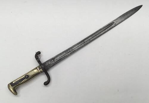 An 1871 pattern Imperial Prussian bayonet, dated 1873.
 Brass handle with diagonally grooved grip and beak pommel.
 Push button rifle release catch built into the handle.
 Steel cross guard with curled quillons to both ends.
 Straight single edged blade, 