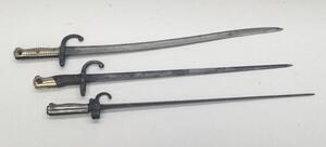 3 19th century French sword bayonets.
 To include, a M1886 Lebel, with hooked quillon and cruciform blade (no scabbard).
 A Gras bayonet, with wooden grips and brass pommel, dated 1876 to the flat spine (no scabbard).
 And a Chassepot bayonet, with ribbed - 4