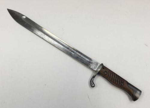 An M1898 pattern Mauser bayonet, also known as the ‘butchers’ bayonet.
 Maker marked to the ricasso for Fichtel & Sachs Schweinfurt.
 Wooden handle with ridged grips, secured by 2 rivets.
 Steel backpiece and pommel, the latter with spring clip for attaching to a rifle.
 Steel cross guard with upswept quillon.
 Steel blade with single fuller to both sides.
 Further marked to the spine of the blade, including a number 15 indicating an issue date of 1915.
 Notes: the blade would have originally ha