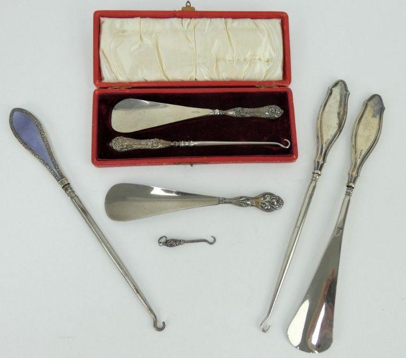 A collection of early 20th Century silver mounted button hooks and