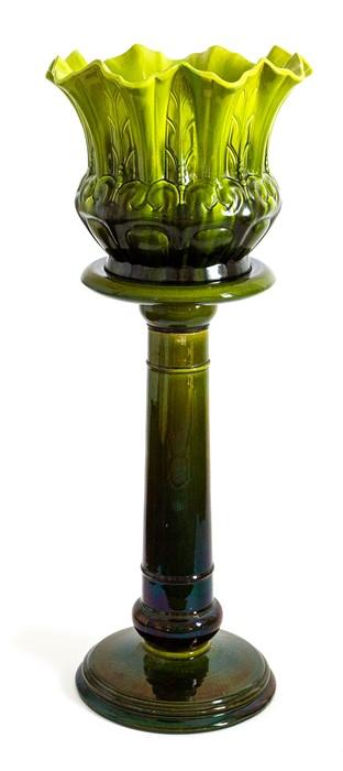 A Bretby Art Pottery jardiniere and stand both decorated with green