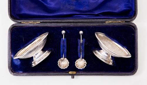 A pair of silver salts, Birmingham 1898/99, John Millward Banks with two shell bowl spoons, Chester 1899 same maker cased