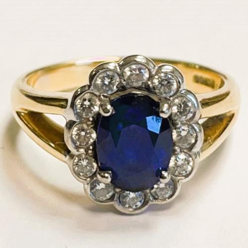 An oval sapphire and diamond cluster 18ct gold ring. Sapphire ...