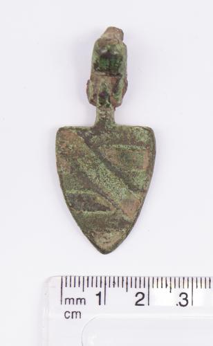 Medieval large copper alloy shield Pendant and hanger showing a single diagonal line from upper left to lower right. It would have once been enamelled but no longer contains any. H30.3mm (not including hanger). W22.9. 14.68g.