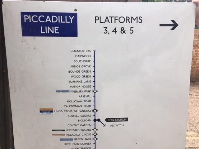 A large vintage enamel Piccadilly Line tube sign