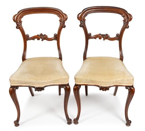 A pair of Victorian rosewood shaped balloon back side chairs, foliate scroll back rests, on shaped cabriole supports with scroll feet, upholstered seats (2)