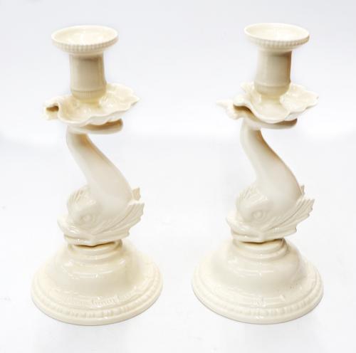 A pair of Regency style 20th Century Leedsware creamware candle sticks, with dolphin stems on raised circular stands